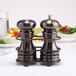 A Chef Specialties burnished copper salt and pepper shaker set on a table.