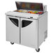 A Turbo Air refrigerated sandwich prep table with a stainless steel top and food in it.