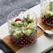 Two Acopa hobnail glass bowls filled with salad and avocado on a table.