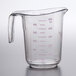 A clear plastic measuring cup with a purple measuring scale and handle.
