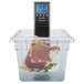 A Breville commercial sous vide immersion circulator head in a container of water with a piece of meat.