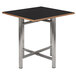 A black square Bon Chef dining table top with a wooden edge.