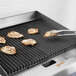 A Cooking Performance Group gas griddle with chicken cooking on it.