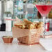 A rose gold square mini fry basket filled with french fries and a drink.