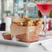 A rose gold square mini fry basket filled with fries and a drink on a table.