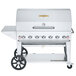 A stainless steel Crown Verity mobile outdoor grill with wheels.