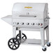 A silver stainless steel Crown Verity mobile outdoor grill with wheels and a stainless steel top.