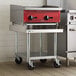 A metal equipment stand with a stainless steel top, undershelf, and casters.