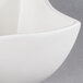 An American Metalcraft white porcelain squavy condiment cup with a curved edge.
