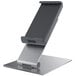 A silver metal tablet stand holding a tablet with a black cover.