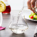 A hand pouring water with a lemon slice into a Chef & Sommelier Warm Tumbler.