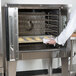 A person putting food into a Garland commercial convection oven.