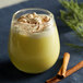 A yellow cup of DaVinci Gourmet Sugar Free Eggnog flavoring syrup with whipped cream and cinnamon sticks.