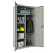 A light gray Hirsh Industries steel wardrobe cabinet in a room with a yellow helmet and a black and red jacket.