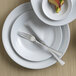 A white plate with a Reserve by Libbey Lucine stainless steel dinner fork on it.