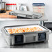 A Cambro Granite Gray Top Loading Food Pan Carrier with food inside on a counter.