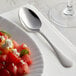 A plate of watermelon salad with an Acopa Vernon stainless steel teaspoon on it.