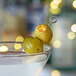 A martini with Belosa Cream Cheese & Habanero Stuffed Queen Olives on a stick.