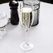 A Chef & Sommelier Cabernet flute filled with champagne with bubbles on a table.