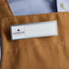 A brown apron with a white rectangular Cawley nametag.