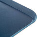 A close up of a dark blue Dinex Glasteel fiberglass tray with a metal edge.