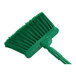 A Carlisle green broom with long handle.