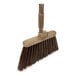 A close up of a Carlisle Sparta Duo-Sweep broom with a brown handle.