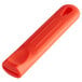 A red silicone pan handle sleeve with a hole.