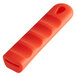 A red silicone pan handle sleeve with a hole for a pan handle.