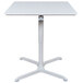 A white square table with a metal base.