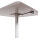 A white square Luxor pneumatic adjustable height cafe table with a black base.