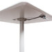 A white square Luxor pneumatic adjustable height cafe table with a black cable.