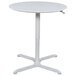 A white Luxor round pneumatic adjustable height cafe table with a metal base.