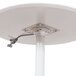 A white round cafe table with a white pneumatic adjustable pole.