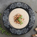 A Fiesta Skull and Vine Foundry china rim soup bowl filled with creamy mushroom soup with mushrooms and herbs.