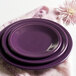A stack of purple Fiesta luncheon plates on a pink napkin.