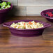 A purple Fiesta oval china baker filled with pasta and salad.