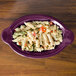 A purple oval Fiesta casserole dish filled with pasta and vegetables.