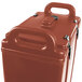 A brick red plastic Cambro insulated soup carrier with handles.
