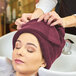 A woman with a Monarch Brands burgundy hand towel on her head.