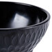 A close-up of a black GET Viva Mexico Melamine Molcajete Bowl with a pattern on it.
