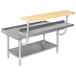 A stainless steel table with an Advance Tabco adjustable plate shelf on a wooden top table.