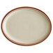 A white oval narrow rim stoneware platter with brown bands.