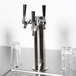 A silver metal Beverage-Air tap tower with black handles on a gray counter.