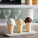 A group of JOY flat bottom cake ice cream cones on a white plate.