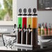 A Beer Tubes flight beer tower with four different colored drinks on a table.