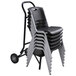 A black Lifetime Stacking Chair Dolly with a stack of black plastic chairs.