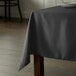 A table with a black Intedge tablecloth on it.