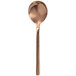 A close-up of a Walco rose gold stainless steel bouillon spoon with a handle.
