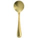 A close-up of a Walco gold stainless steel bouillon spoon with a white background.
